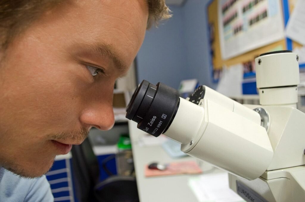 PublicDomainPictures via Pixabay, https://pixabay.com/photos/people-scientist-microscope-white-219985/