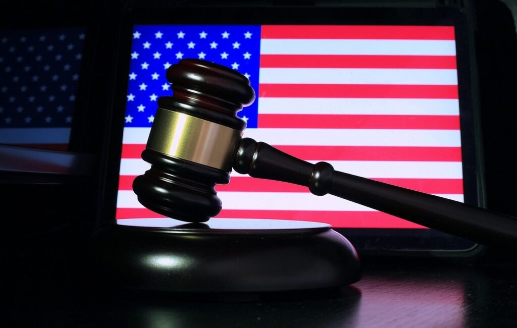 sergeitokmakov via Pixabay, https://pixabay.com/photos/gavel-usa-flag-justice-judge-7473645/